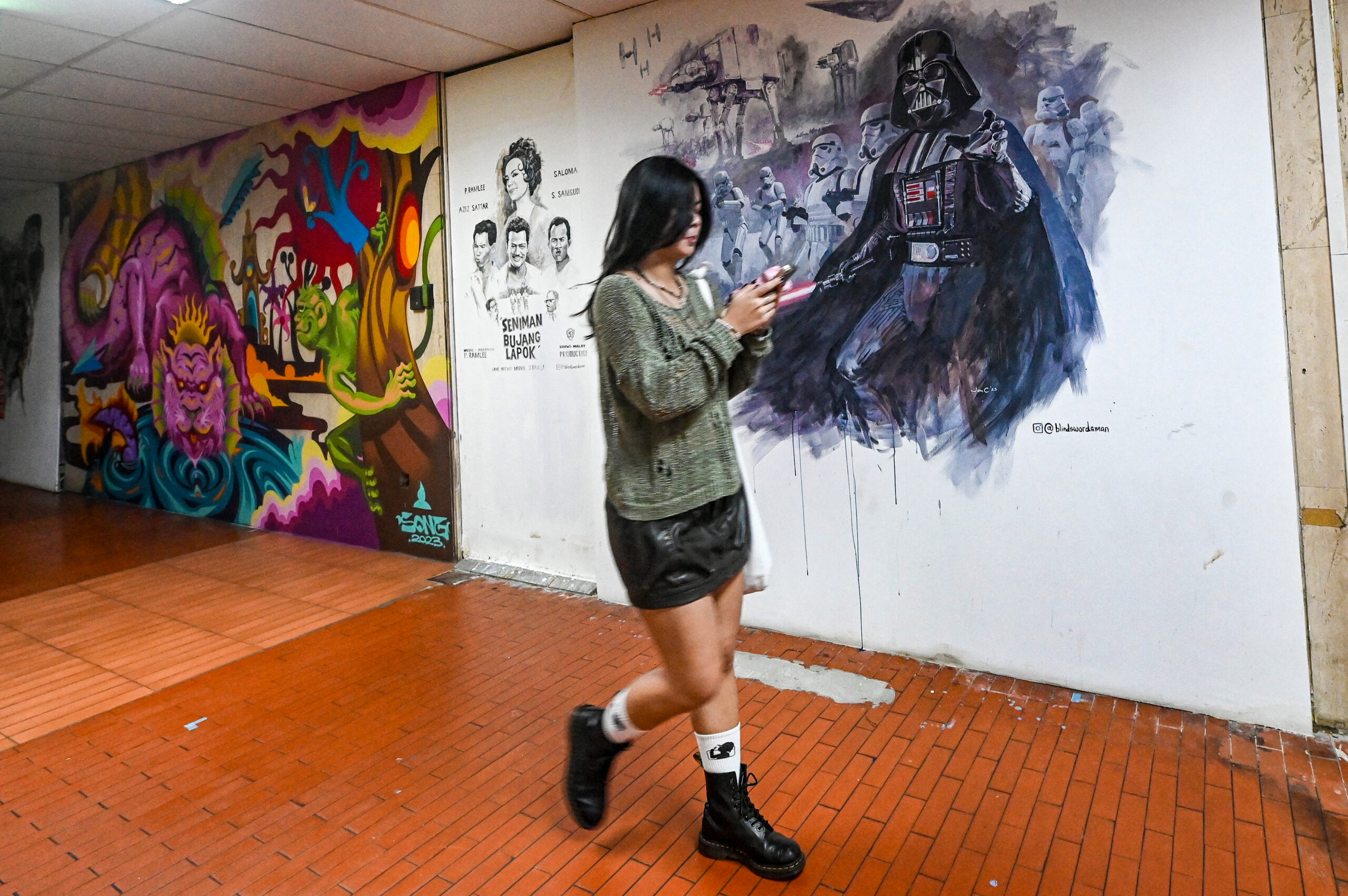 A girl walks past an impressive Star Wars mural