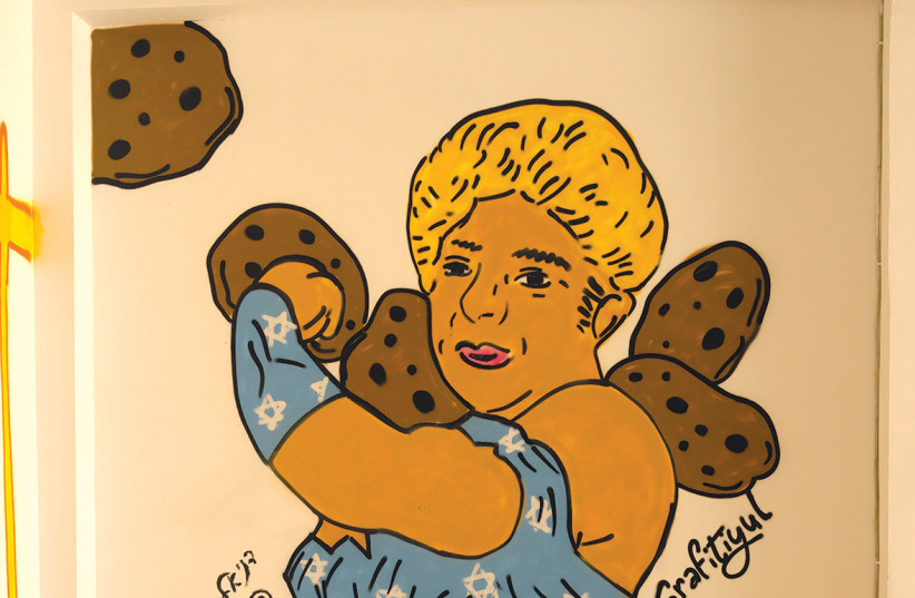 ‘Rachel and the Cookies’ by Grafitiyul, depicts Rachel Edri as Wonder Woman, based on an illustration by Daniel Amit.  (credit: Suzi Bar)