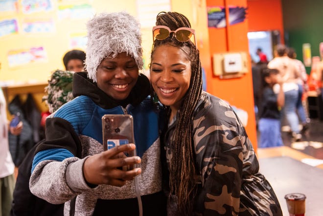 Jeremiah Kelly of Detroit, 12, left, takes a selfie with comedian Tiffany 