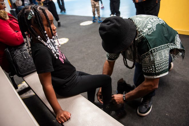 Damon Riddick, right, helps his granddaughter, Kendall Palmer, 8, left, with her roller skates during Dilla Family Day at the Alkebu-lan Village on Saturday, Feb. 10, 2024 in Detroit. The event featured roller skating, educational workshops and a pizza lunch.
