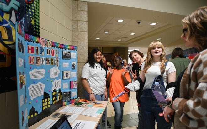 Lansing Eastern freshman Stella Canfield {second from r.) talks about her team's hip-hop museum station she and fellow Honors English freshman and sophomore students created as part of their project-based learning class 'Finding Common Ground: This is Hip-Hop 50th Anniversary