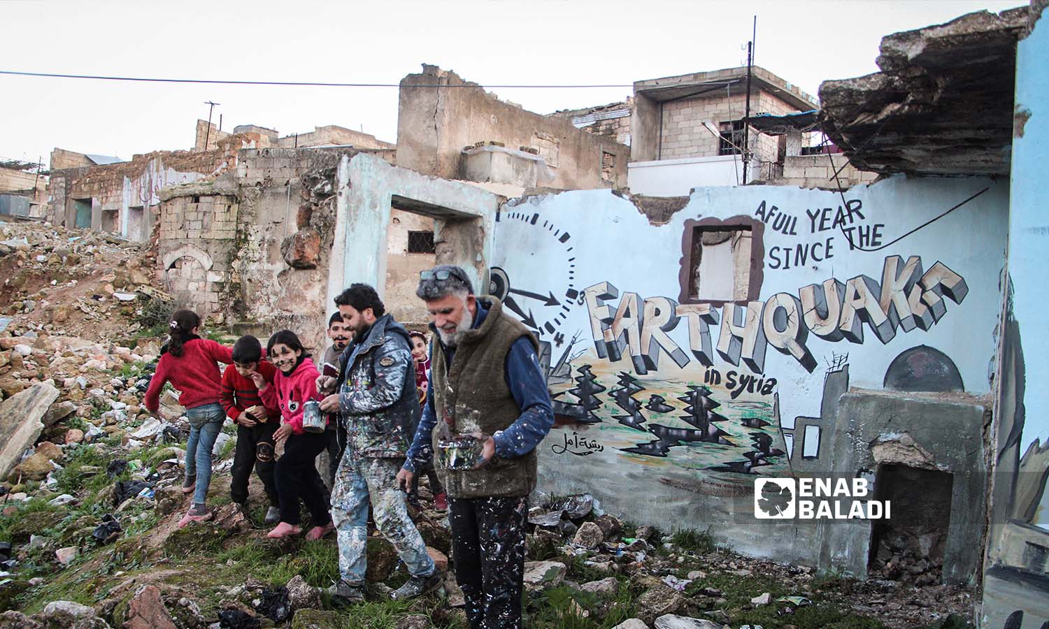 The Feather Hope team paints a mural on the walls of a house destroyed by the earthquake that struck northwestern Syria - February 6, 2024 (Enab Baladi/Abdul Karim al-Thalji)