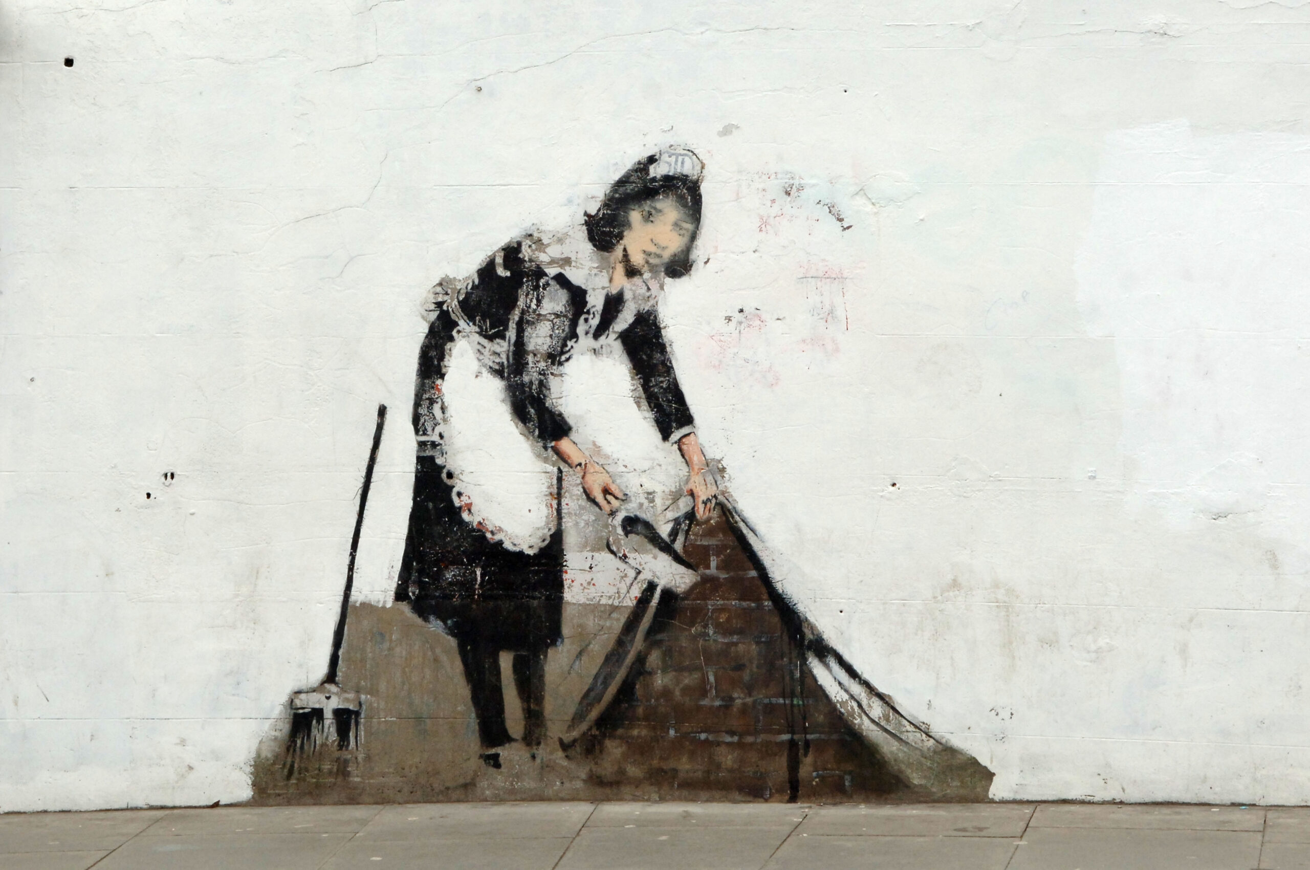 Sweep It Under The Carpet Maid by Banksy in Camden London England