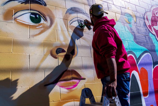 Indianapolis street artist Kwazar Martin puts the finishing touches Monday, March 11, 2024, on his most recent graffiti mural of Iowa Hawkeyes basketball player Caitlin Clark. Clark is the community favorite for the Indiana Fever's upcoming No. 1 WNBA draft pick.
