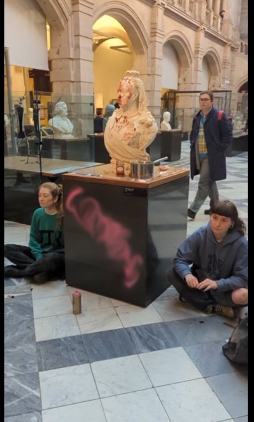 This is Rigged stage a cost of living protest at Kelvingrove, Glasgow smearing porridge and jam over the bust of Queen Victoria - before spray painting the plinth and then supergluing themselves to it Images from This is Rigged https://www.thisisrigged.org/media