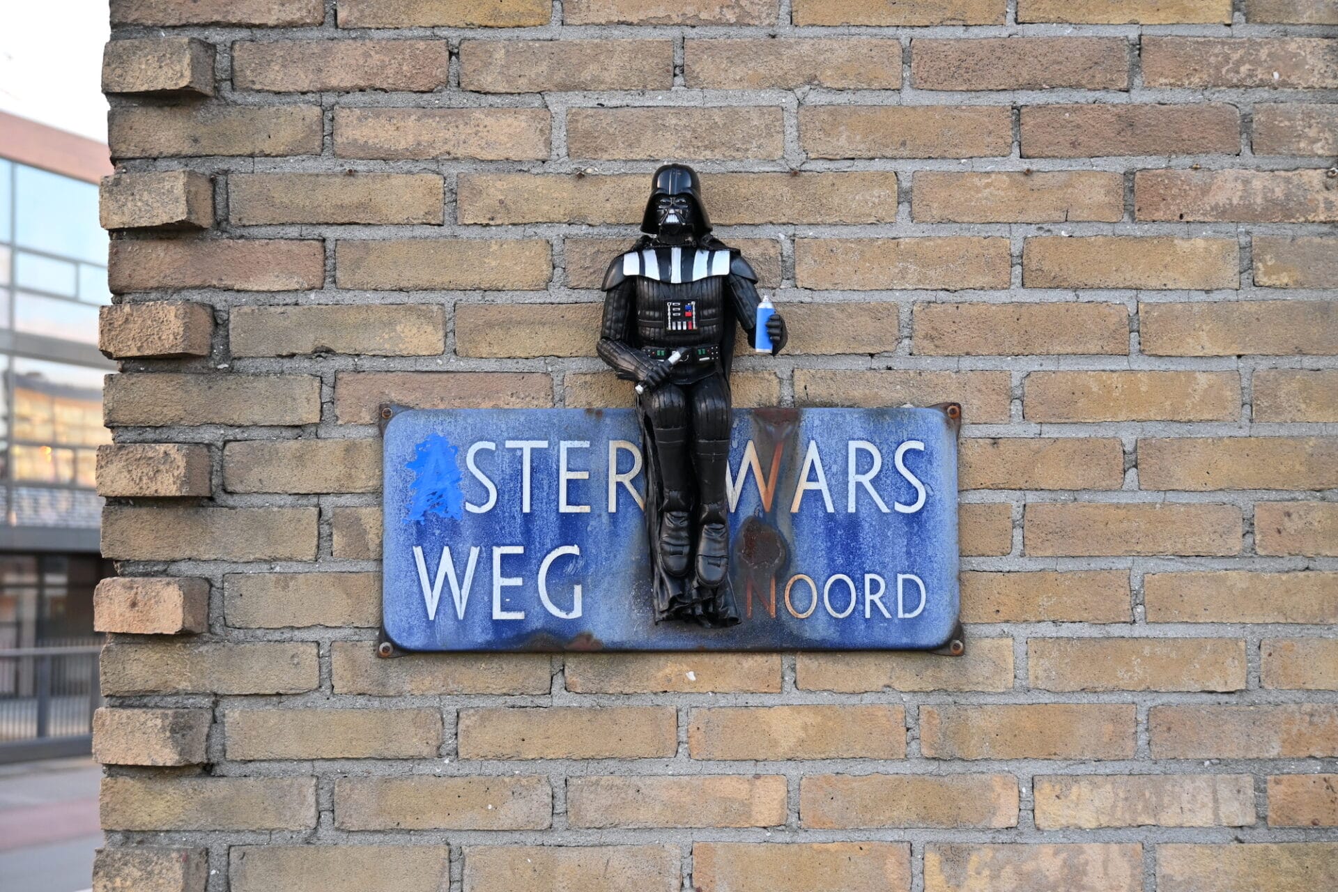 A sculpture of Darth Vader is placed onto a sign that reads 