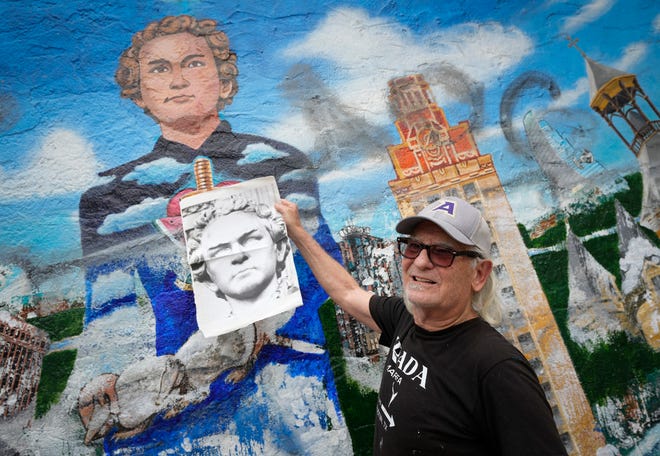 Kerry Awn helps restore the “Austintatious” mural he originally painted with Tom Bauman and Rick Turner as University of Texas art students in 1973, on the north wall of the University Co-Op Monday April 1, 2024.