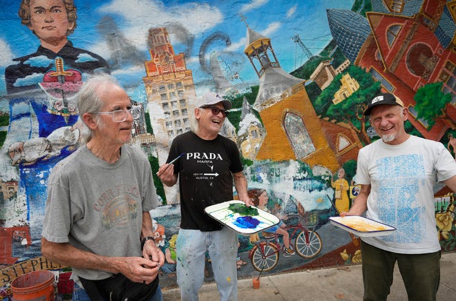 Tom Bauman, left to right, Kerry Awn and Rick Turner restore their “Austintatious” mural they originally painted as University of Texas art students in 1973, on the north wall of the University Co-Op Monday April 1, 2024.