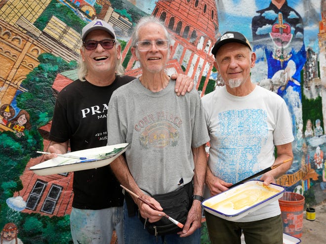 Kerry Awn, left to right, Tom Bauman and Rick Turner are restoring their “Austintatious” mural they originally painted as University of Texas art students in 1973, on the north wall of the University Co-Op Monday April 1, 2024.