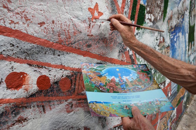 Tom Bauman helps restore the “Austintatious” mural he originally painted with Kerry Awn, and Rick Turner as University of Texas art students in 1973, on the north wall of the University Co-Op Monday April 1, 2024.