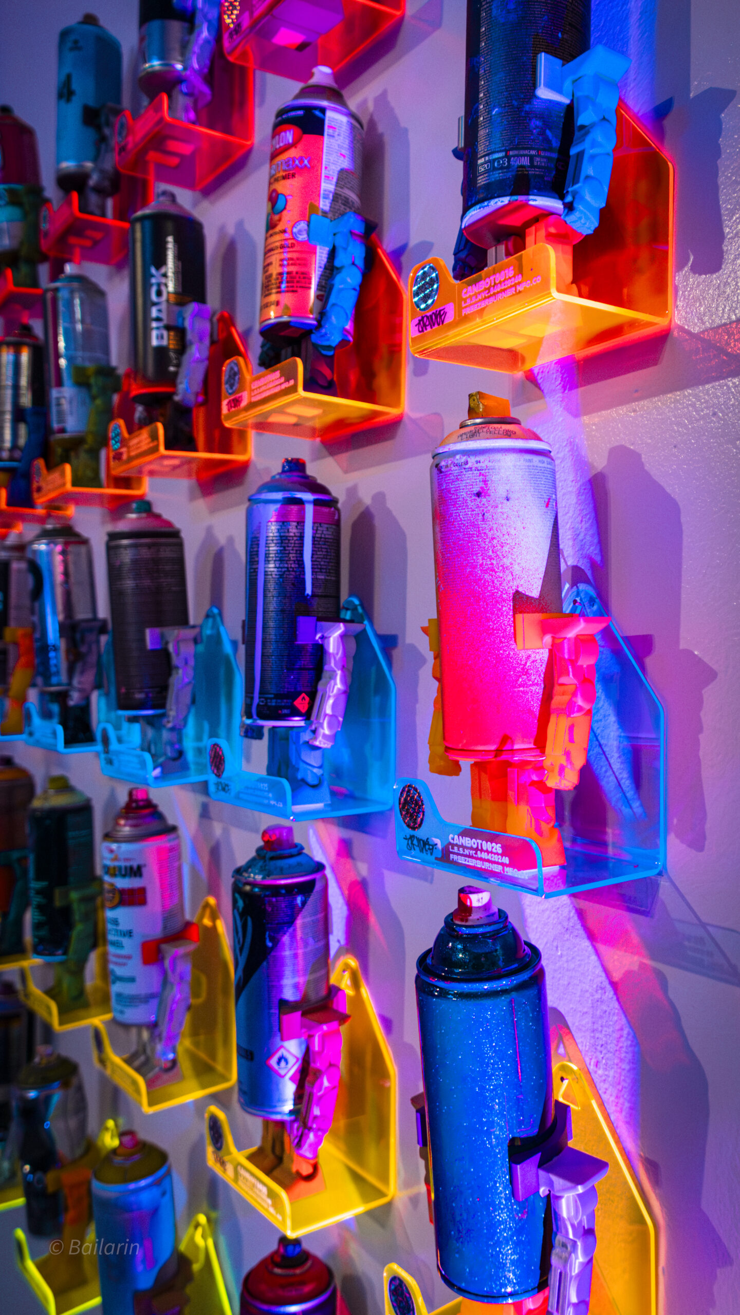 Spray cans with arms and legs attached to it on plexiglass shelves