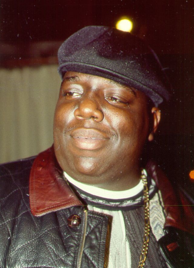 biggie smalls smiling and looking out of frame in a photograph