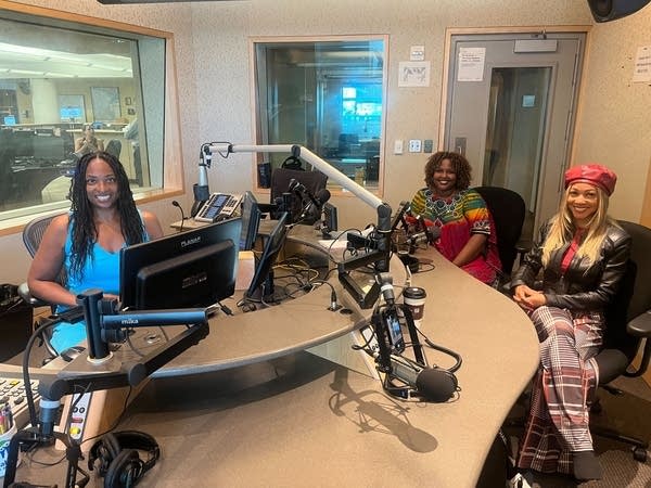 Three women sitting in a broadcast studio