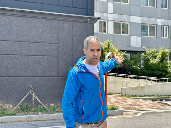 JonOne speaks to press in front of the Palace Park apartment complex in Shinan County, South Jeolla, on July 5, before beginning work on his graffiti piece. [SHIN MIN-HEE]