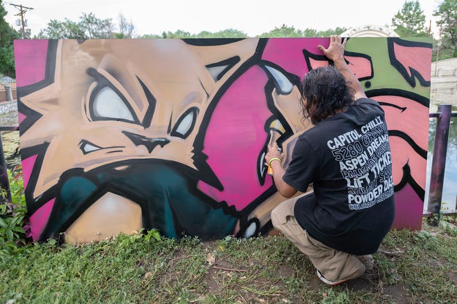 Artist Kool Cat Tin Man adds fine details to his graffiti art during the second annual Hip Hop Festival at Mineral Palace Park on Saturday, July 20, 2024.