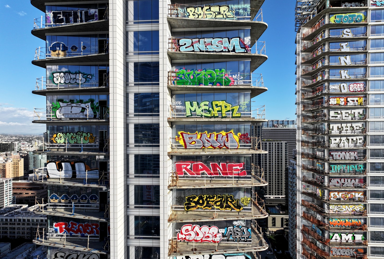 An aerial view of graffiti spray painted by taggers on at least 27 stories of an unfinished skyscraper development...