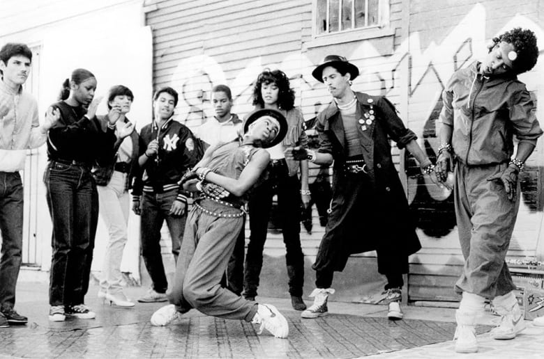 A black and white screen grab from the film Breakin' with young people dancing in the street.