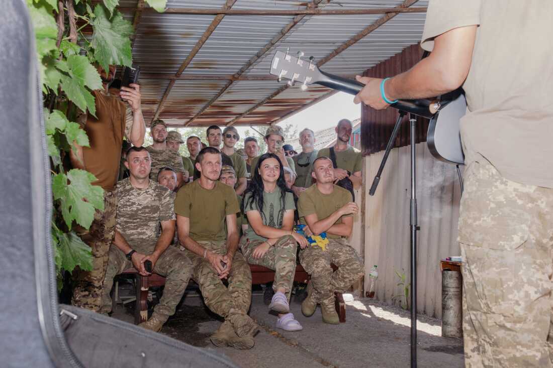 Ukrainian soldiers watch a music performance in a driveway of the home where currently being used as a base, on the front in eastern Ukraine.