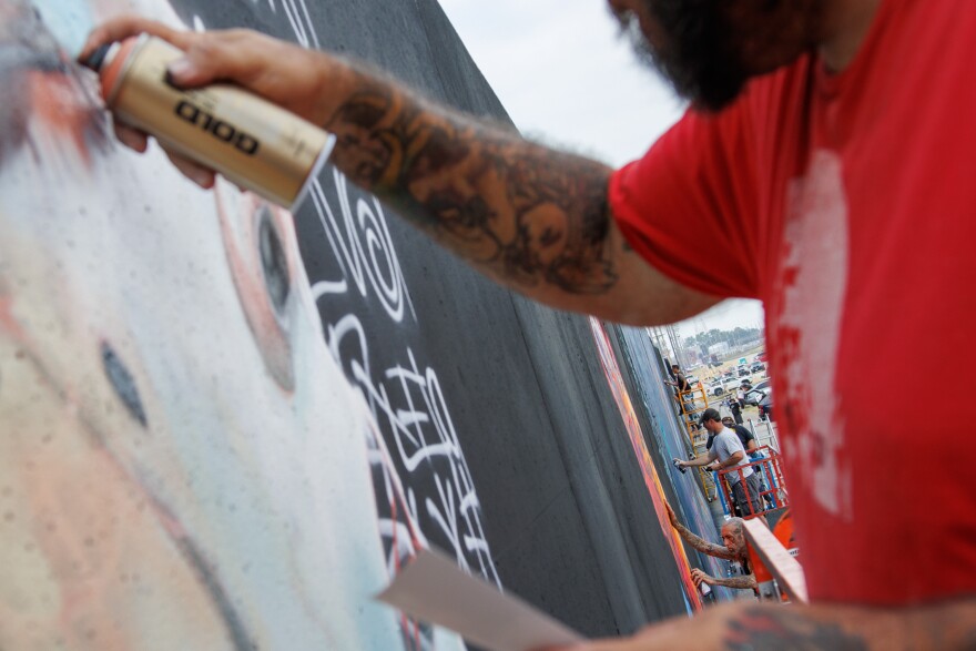 Artists spray paint their work along the Mississippi River on Friday, August 30, 2024.