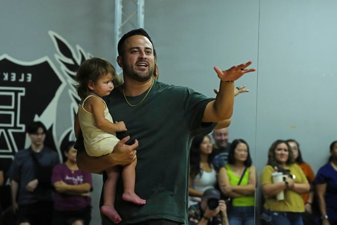 Nico Banuelos holds his daughter Braydi, 1, as he tells parents what to expect for the Hip Hop International's World Hip Hop Dance Championship Aug. 1, 2024, in Mesa, Arizona.