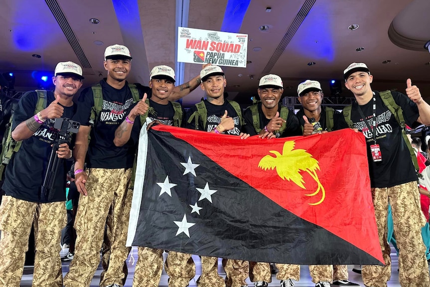 Seven men hold the Papua New Guinea flag at the world championships.