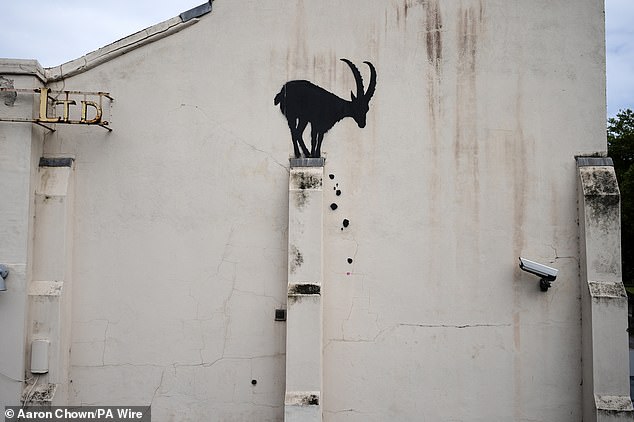 The artist's new piece in London features the goat silhouette with rocks falling down below it