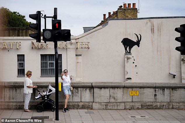 The artist's new piece in London features the goat silhouette with rocks falling down below it