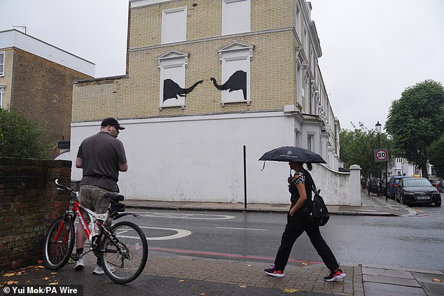 A man stops to look at a new artwork depicting two elephants in Chelsea, South West London