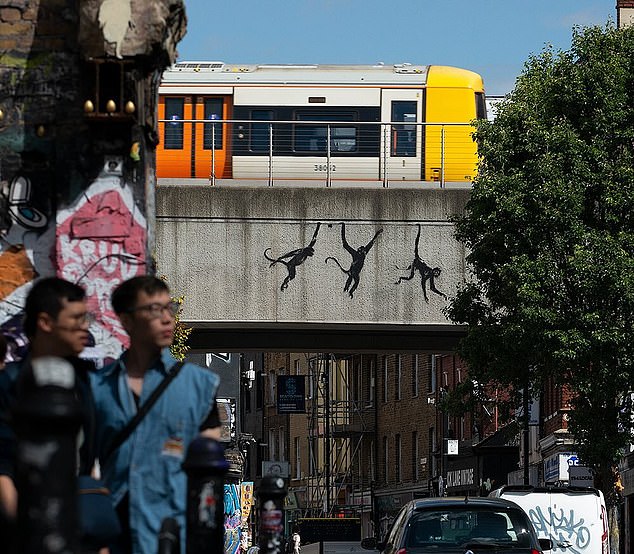 On Wednesday, Banksy confirmed that the three monkeys looking as though they were swinging underneath a bridge over Brick Lane, east London, as the third artwork in the series