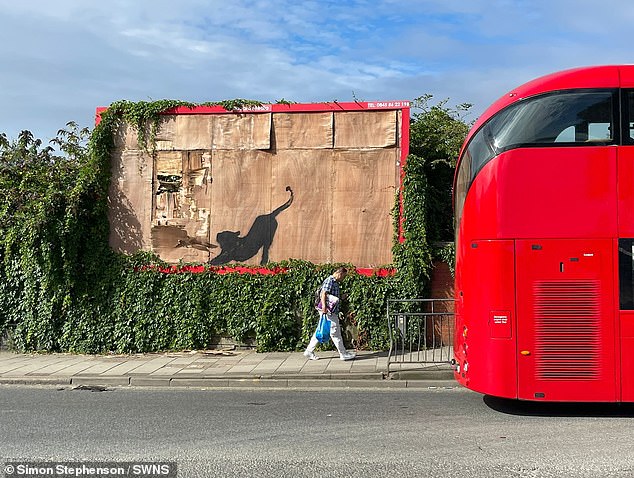 On Saturday, a large cat silhouette was sprayed onto an abandoned billboard in Cricklewood, appearing to show the animal stretching and scratching at a broken part of the wood