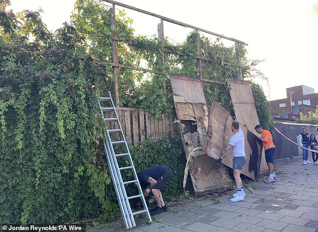 Contractors were later seen taking down Banksy's sixth animal-themed artwork, the silhouette of a cat on a billboard in Cricklewood