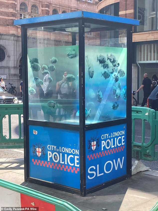 Banksy's artwork of piranhas swimming on a police sentry box has been taken away by council officials from the City of London to a safe location, amid fears that it could be otherwise stolen