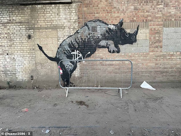 A vandal has now damaged with a spraypainted 'tag' the rhino mural by Banksy which was unveiled in Charlton, south-east London, on Monday