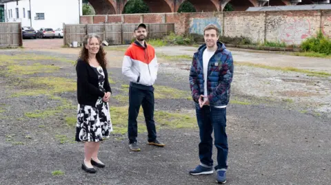 Steve Brock Photography  Left to right: Tracey Moore (left) from Project North East, Carlo Viglianisi of Building Culture and Mark Shields at the Woods Pottery site. Brick walls and a wooden fence in the background