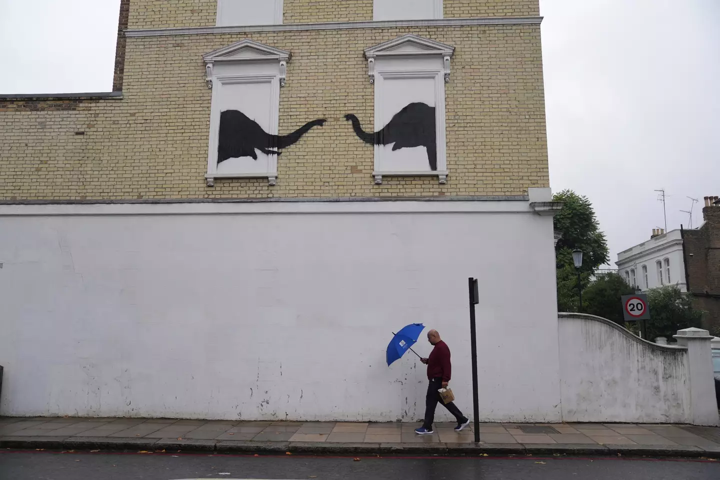 Banksy's art depicts two elephants poking their heads out of blocked-out windows. (PA)