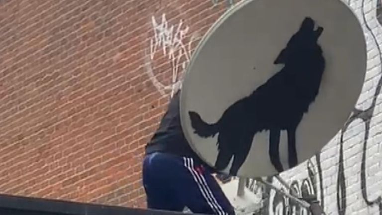 A new Banksy artwork featuring a wolf has been taken away by people wearing masks.