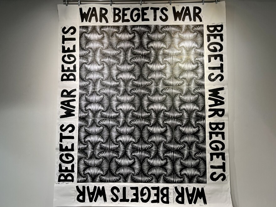 A black and white art piece with the words war begets war looping around as a border.