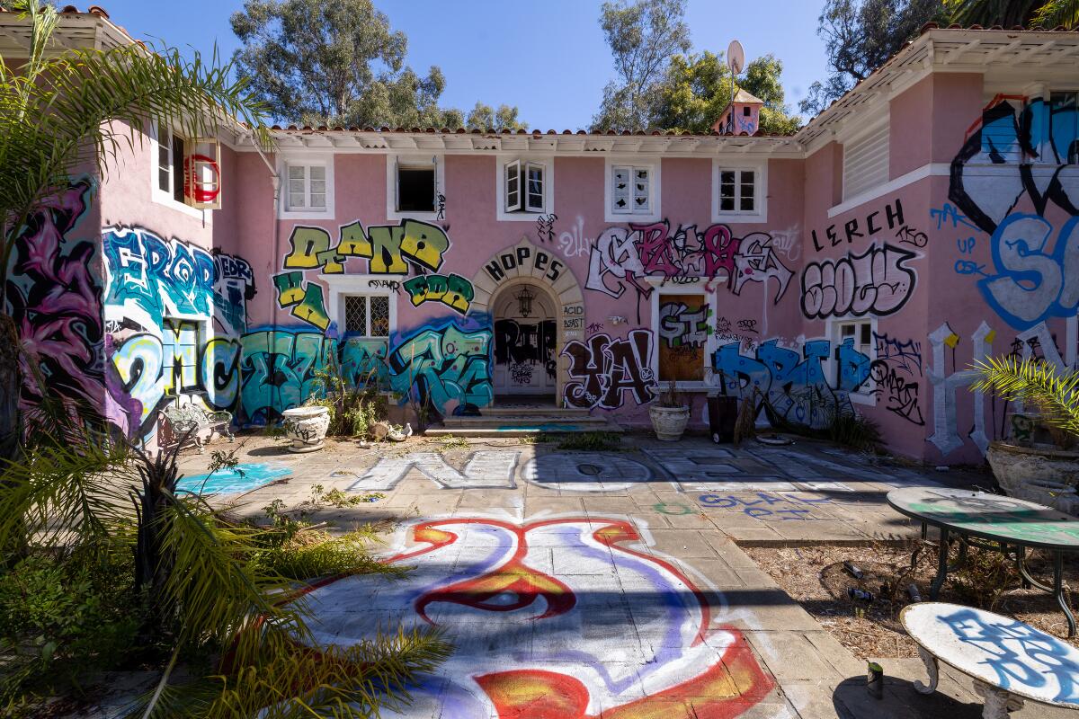 A graffiti vandalized front entrance to a mansion.