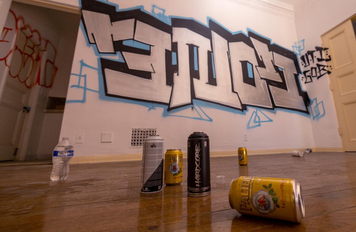 Spray paint and empty beer cans are inside a graffiti-covered mansion.