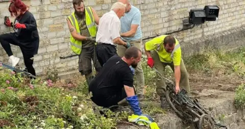 Terrence Pippin People in high-viz jackets clearing out river