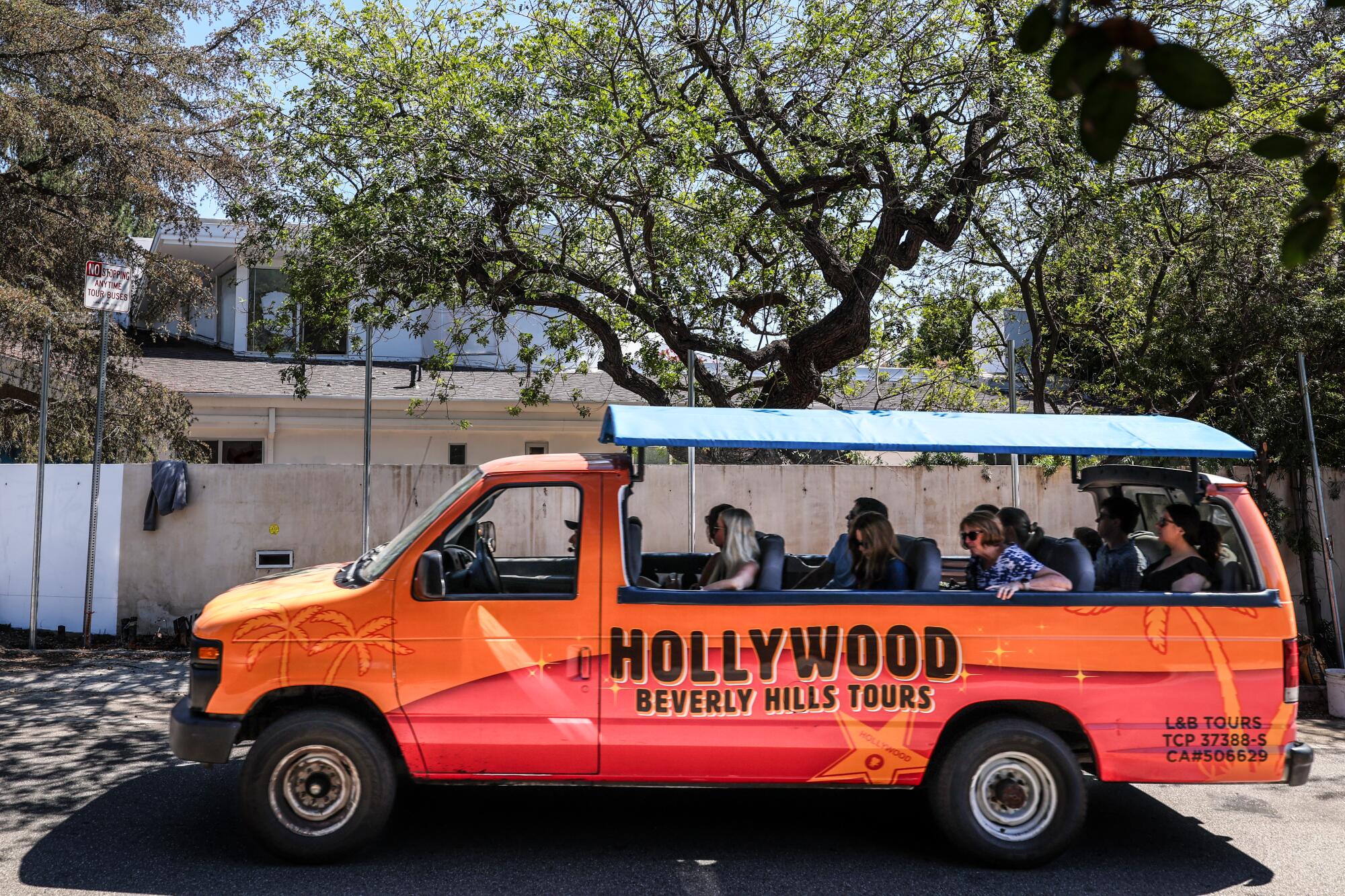 A tour van passes the abandoned mansion along Mulholland Drive.