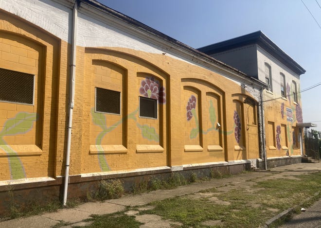 A block-long mural puts blooming flowers along the side of a building at 10th and Elm streets.