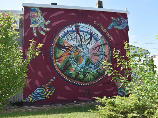 A mural appears to cast a spell from the wall of a house on the 900 block of North 5th Street in North Camden.