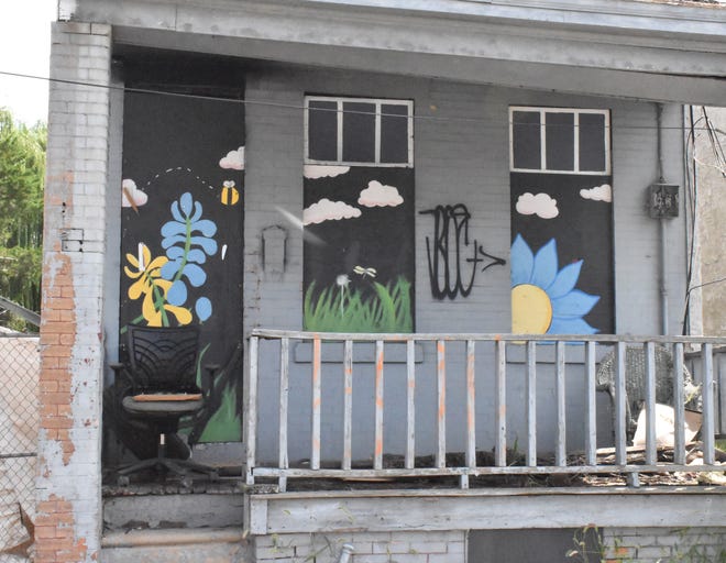 Paintwork brightens an abandoned home, one of many in North Camden.