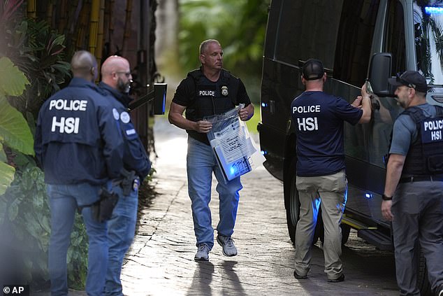 Monday evening's indictment comes less than six months after the music mogul's homes in Los Angeles and Miami were raided by federal authorities March 25. Officials pictured in Miami Beach