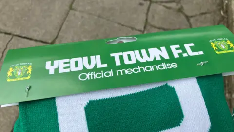 Picture of green Yeovil scarf with misspellings on the packaging including 