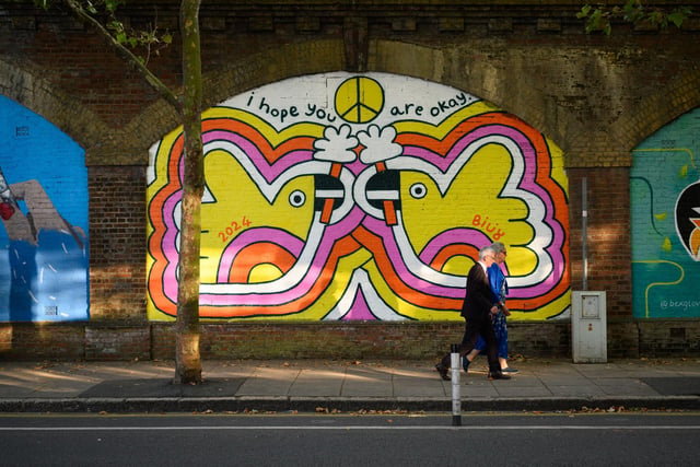 Pictured is: A couple walk past one of the many artworks along the railway arches by the Hard.  Picture: Keith Woodland (140921-114)