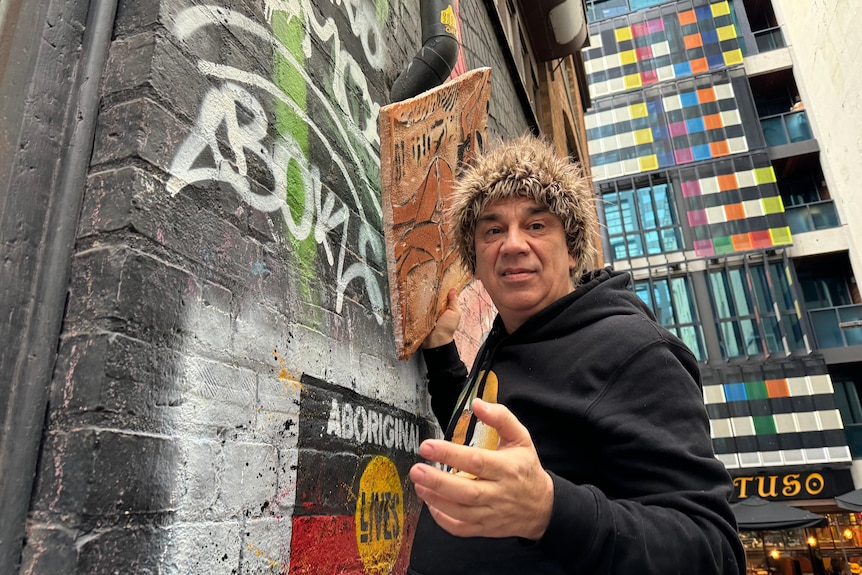 A man creating street art in an alleyway