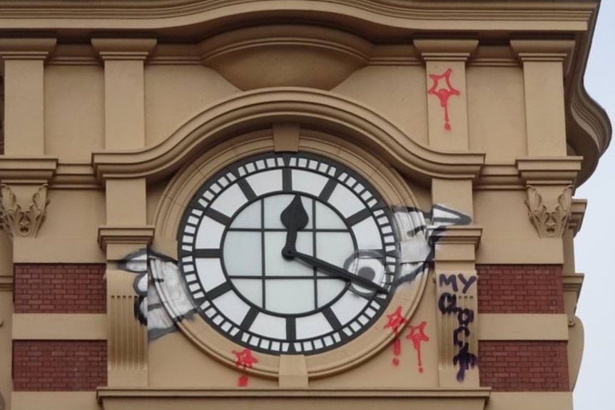 A clock face that has been vandalised