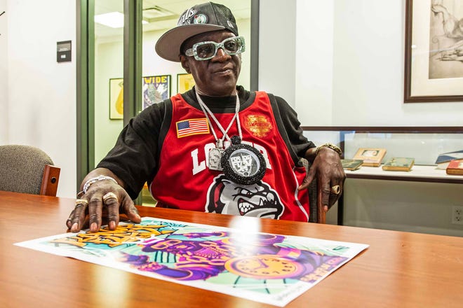 Headliner Flavor Flav sits at a table the second Hip Hop Cultural Summit at the Delaware Art Museum in Wilmington, Saturday, Oct. 27, 2024.